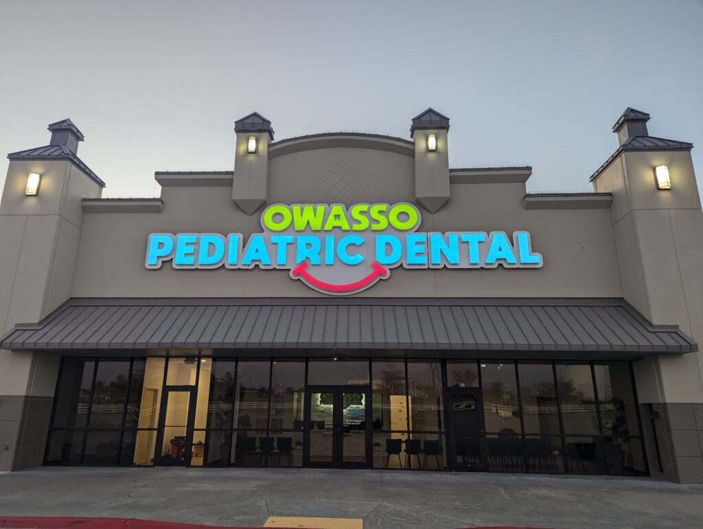 front of a large dentist office with glass front and large sign reading "owasso pediatric dental"